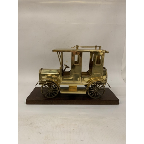 106 - A SOLID BRASS TAXI MODEL ON A WOODEN PLINTH