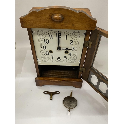 35 - A CARVED WOOD CASED GERMAN 8 DAY STRIKING MANTLE CLOCK WITH KEY AND PENDULUM