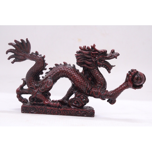 267 - A RED RESIN ORIENTAL DRAGON, HEIGHT 12CM, LENGTH 23CM