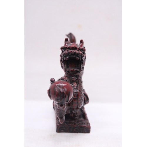 267 - A RED RESIN ORIENTAL DRAGON, HEIGHT 12CM, LENGTH 23CM