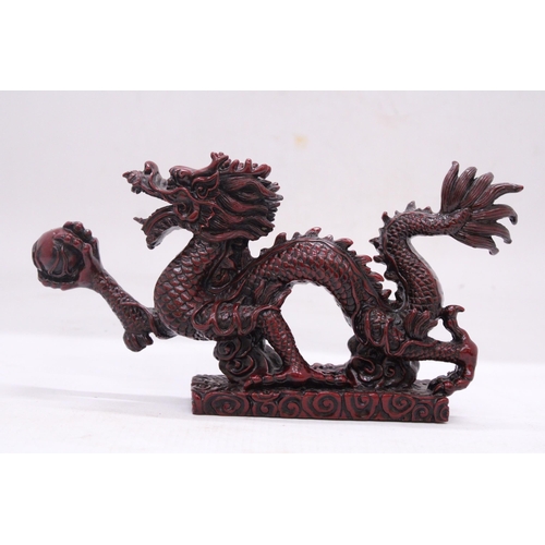 267 - A RED RESIN ORIENTAL DRAGON, HEIGHT 12CM, LENGTH 23CM