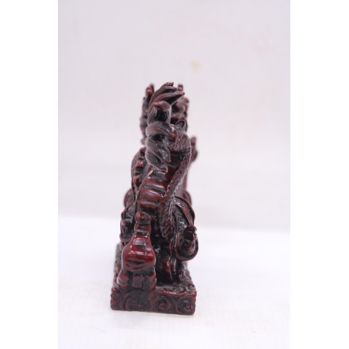 267 - A RED RESIN ORIENTAL DRAGON, HEIGHT 12CM, LENGTH 23CM