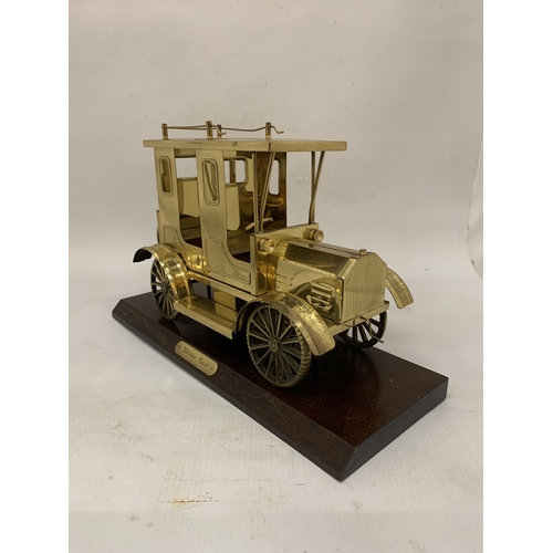 106 - A SOLID BRASS TAXI MODEL ON A WOODEN PLINTH