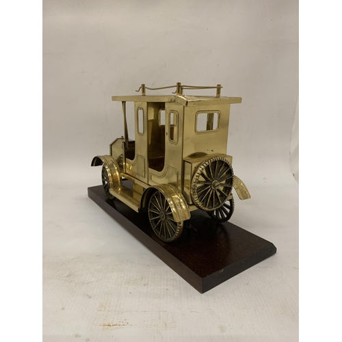 106 - A SOLID BRASS TAXI MODEL ON A WOODEN PLINTH