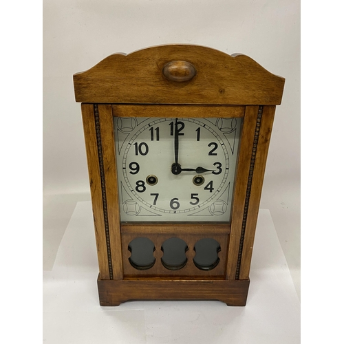 35 - A CARVED WOOD CASED GERMAN 8 DAY STRIKING MANTLE CLOCK WITH KEY AND PENDULUM