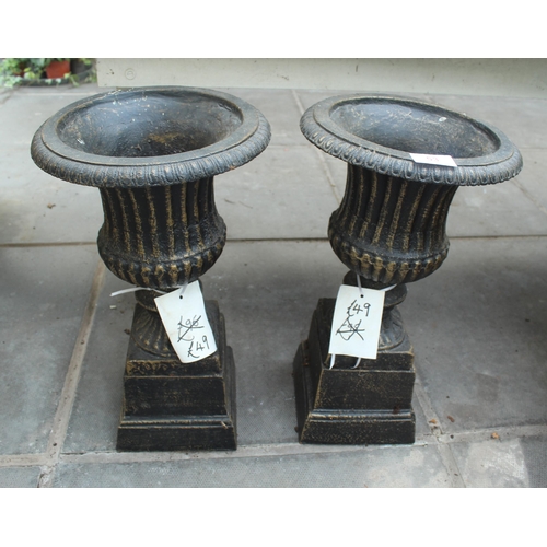 53 - TWO CAST IRON URNS ON PLINTHS PLUS VAT