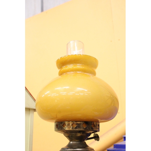 380 - A VINTAGE OIL LAMP WITH MUSTARD COLOURED GLASS SHADE