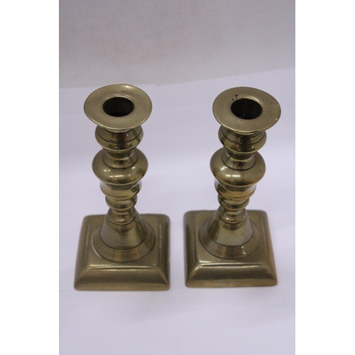 499 - A PAIR OF GEORGIAN BRASS CANDLESTICKS