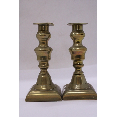 499 - A PAIR OF GEORGIAN BRASS CANDLESTICKS