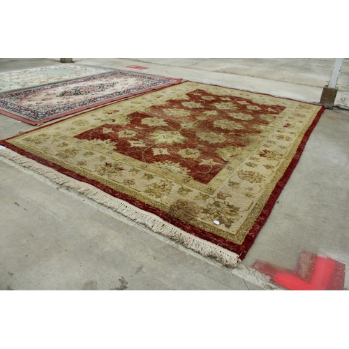 2494 - A RED AND CREAM PATTERNED FRINGED RUG