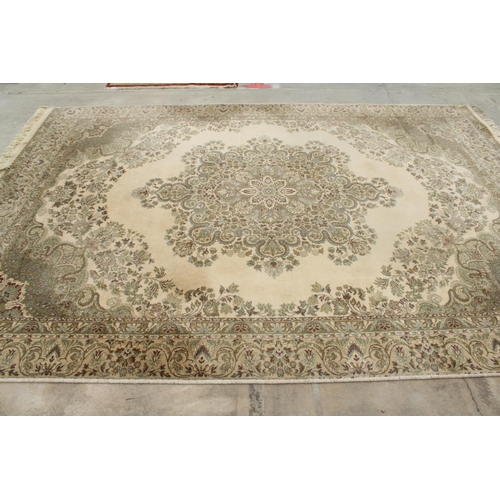 2497 - A LARGE CREAM PATTERNED FRINGED RUG