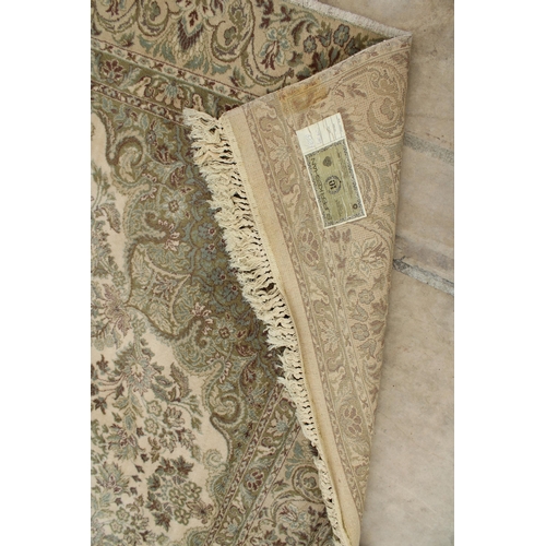 2497 - A LARGE CREAM PATTERNED FRINGED RUG