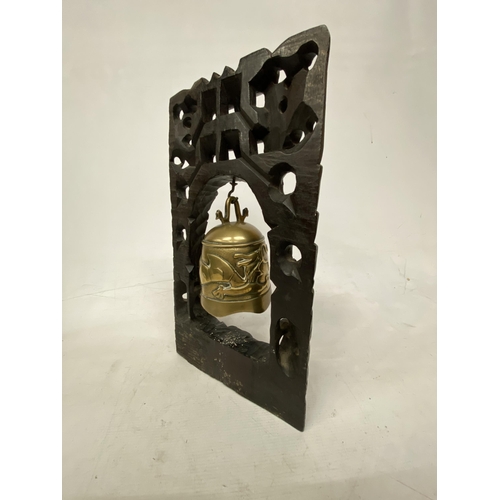 2 - A CHINESE TEMPLE BELL DECORATED WITH DRAGONS SUPPORTED WITHIN A CARVED HARD WOOD STAND