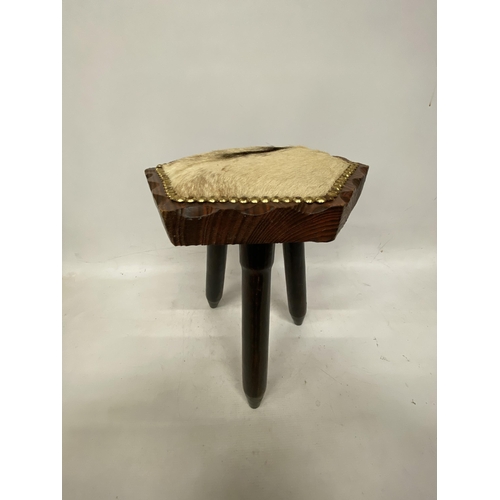 67 - A THRRE LEGGED MILKING STOOL WITH COW HIDE SEAT HEIGHT 41CM