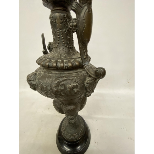 87 - A PAIR OF CAST DECORATIVE EWERS WITH CHERUBS ON A BASES HEIGHT 54CM