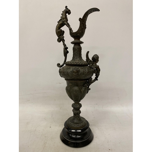 87 - A PAIR OF CAST DECORATIVE EWERS WITH CHERUBS ON A BASES HEIGHT 54CM