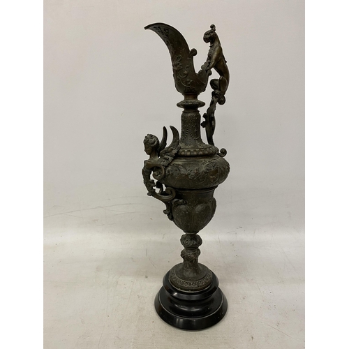 87 - A PAIR OF CAST DECORATIVE EWERS WITH CHERUBS ON A BASES HEIGHT 54CM