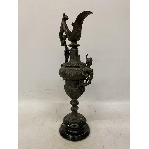 87 - A PAIR OF CAST DECORATIVE EWERS WITH CHERUBS ON A BASES HEIGHT 54CM