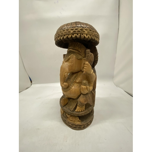 188 - A HAND CARVED WOODEN FIGURE OF GANESH, HEIGHT 26CM