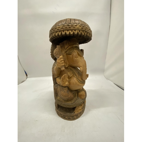 188 - A HAND CARVED WOODEN FIGURE OF GANESH, HEIGHT 26CM