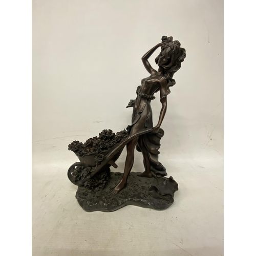 214 - A LARGE FIGURINE OF A WOMAN WITH WHEELBARROW FULL OF FLOWERS APPROXIMATLEY - 47CM HIGH