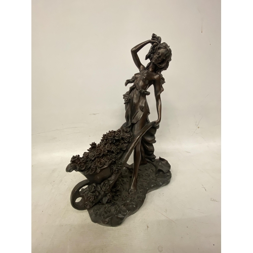 214 - A LARGE FIGURINE OF A WOMAN WITH WHEELBARROW FULL OF FLOWERS APPROXIMATLEY - 47CM HIGH