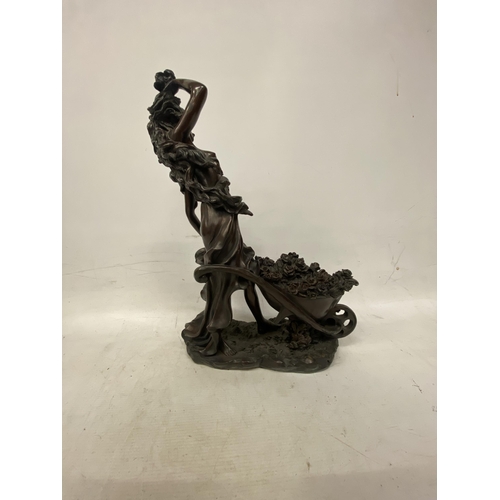 214 - A LARGE FIGURINE OF A WOMAN WITH WHEELBARROW FULL OF FLOWERS APPROXIMATLEY - 47CM HIGH