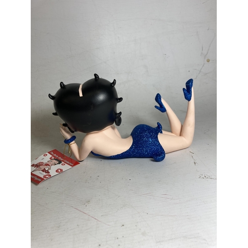 23 - A BETTY BOOP FIGURE LYING DOWN IN A BLUE GLITTER DRESS - 13 CM (H) 20.5 CM (L)