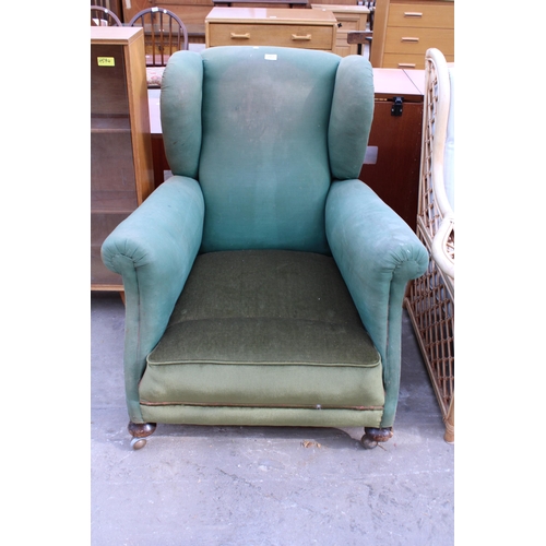 2953 - AN EDWARDIAN SPRUNG AND UPHOLSTERED WINGED EASY CHAIR ON FRONT BUN FEET