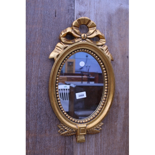 2988 - A GILT EFFECT OVAL WALL MIRROR, 18