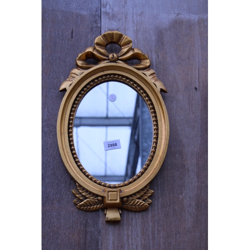 2988 - A GILT EFFECT OVAL WALL MIRROR, 18