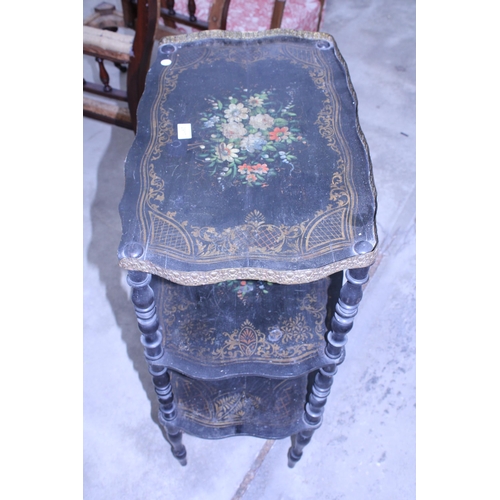 2917 - A VICTORIAN STYLE THREE TIER BLACK PAINTED WHAT NOT WITH FLORAL PAINTED DECORATION AND EMBOSSED BRAS... 