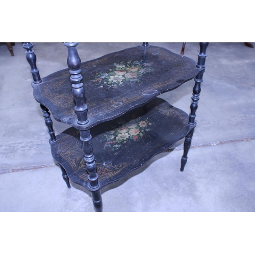 2917 - A VICTORIAN STYLE THREE TIER BLACK PAINTED WHAT NOT WITH FLORAL PAINTED DECORATION AND EMBOSSED BRAS... 