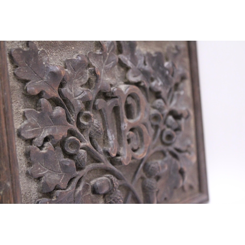 252 - AN ANTIQUE WOODEN WALL PLAQUE CARVED WITH ACORN AND OAK LEAF DECORATION, 24CM X 17CM