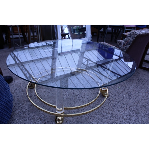 3055 - A MODERN 39 INCH DIAMETER GLASS TOP COFFEE TABLE ON GOLD COLOURED METAL FRAME AND CLEAR PLASTIC LEGS