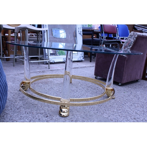 3055 - A MODERN 39 INCH DIAMETER GLASS TOP COFFEE TABLE ON GOLD COLOURED METAL FRAME AND CLEAR PLASTIC LEGS