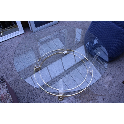 3055 - A MODERN 39 INCH DIAMETER GLASS TOP COFFEE TABLE ON GOLD COLOURED METAL FRAME AND CLEAR PLASTIC LEGS