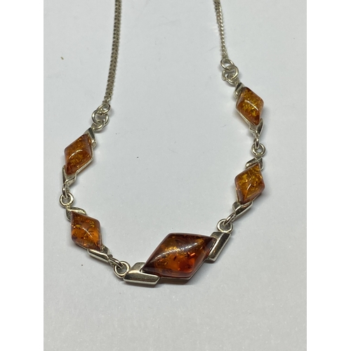 650 - A MARKED SILVER AND AMBER NECKLACE (MARKED ON EVERY LINK) WITH A PINK POUCH