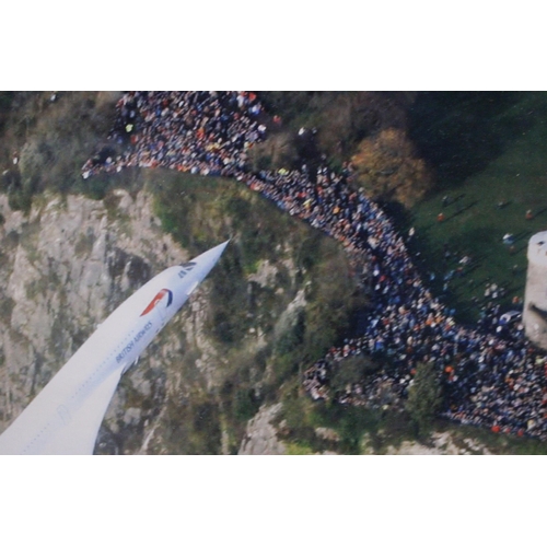 1027 - A PRINT DEPICTING THE LAST FLIGHT OF CONCORDE, FLYING LOW OVER BRUNEL'S CLIFTON BRIDGE, 87CM X 72CM