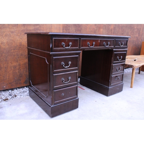 2510 - A MAHOGANY TWIN PEDESTAL DESK ENCLOSING EIGHT DRAWERS WITH INSET LEATHER TOP, 48