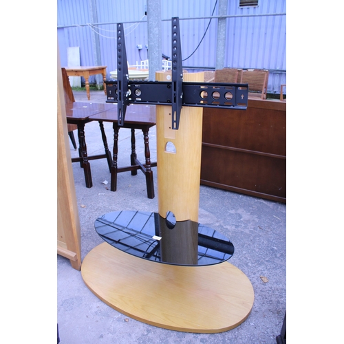 2573 - AN ADJUSTABLE FLAT SCREEN T.V. STAND ON OVAL BASE AND OVAL BLACK GLASS SHELF