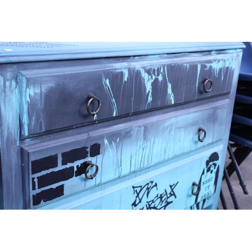 2661 - A MID 20TH CENTURY PAINTED CHEST OF THREE DRAWERS WITH BANKSY STYLE DECORATION, 36