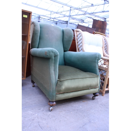 2953 - AN EDWARDIAN SPRUNG AND UPHOLSTERED WINGED EASY CHAIR ON FRONT BUN FEET