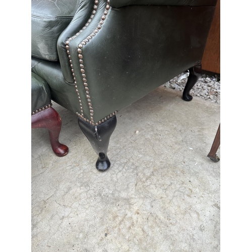 2525 - A GREEN LEATHER BUTTON-BACK WINGED FIRESIDE CHAIR ON CABRIOLE LEGS AND MATCHING STOOL