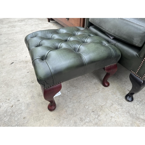 2525 - A GREEN LEATHER BUTTON-BACK WINGED FIRESIDE CHAIR ON CABRIOLE LEGS AND MATCHING STOOL