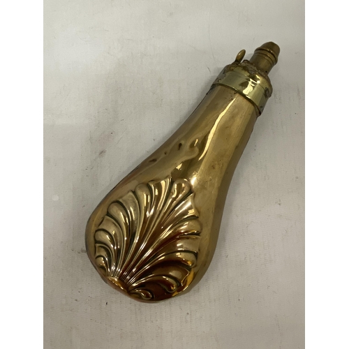 7 - A 19TH CENTURY COPPER POWDER FLASK WITH BOTH SIDES EMBOSSED WITH A SHELL WITH BRASS CHARGER