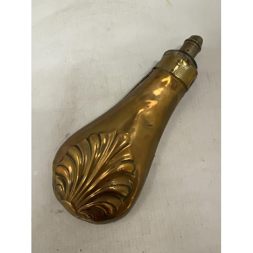 7 - A 19TH CENTURY COPPER POWDER FLASK WITH BOTH SIDES EMBOSSED WITH A SHELL WITH BRASS CHARGER