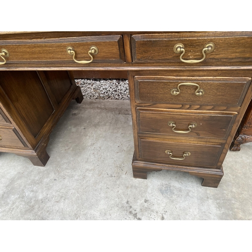 2513 - AN EDWARDIAN STYLE TWIN-PEDESTAL DESK ENCLOSING EIGHT DRAWERS WITH INSET LEATHER TOP, 54