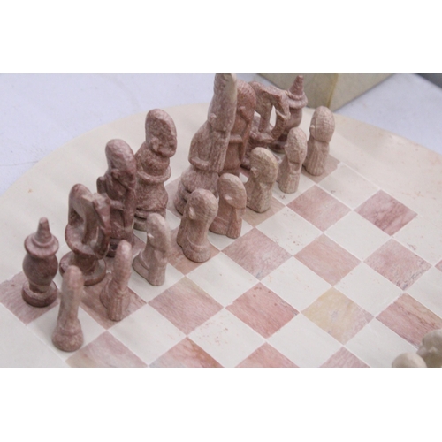 117 - A CARVED SOAPSTONE AFRICAN THEMED CHESS SET - COMPLETE