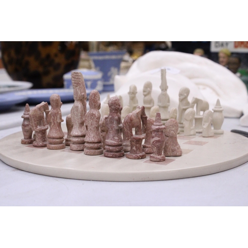 117 - A CARVED SOAPSTONE AFRICAN THEMED CHESS SET - COMPLETE